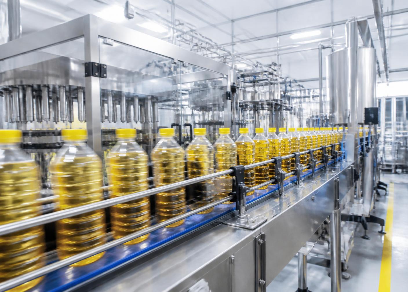 Sunflower oil bottles moving along an automated filling and sealing line