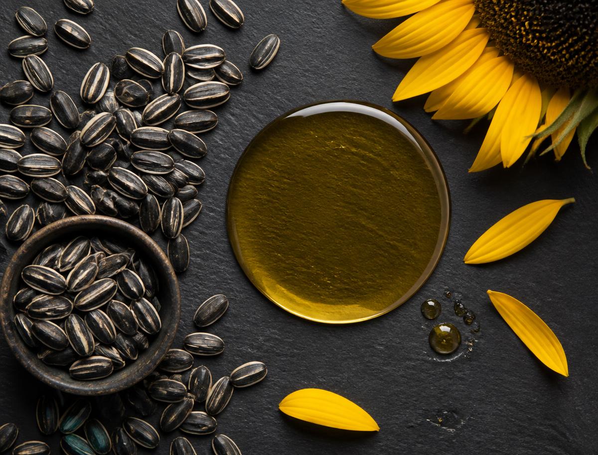 Sunflower seeds beside a pool of golden oil